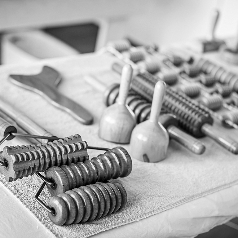 Wood massage, maderotherapy, wooden rolling pin or battledore tools for anti cellulite treatment to stimulate the lymphatic system and improve circulation concept